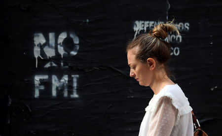 A woman walks past a graffiti that reads "No to the IMF (International Monetary Fund)" in Buenos Aires' financial district, Argentina October 18, 2018. Picture taken October 18, 2018. REUTERS/Marcos Brindicci