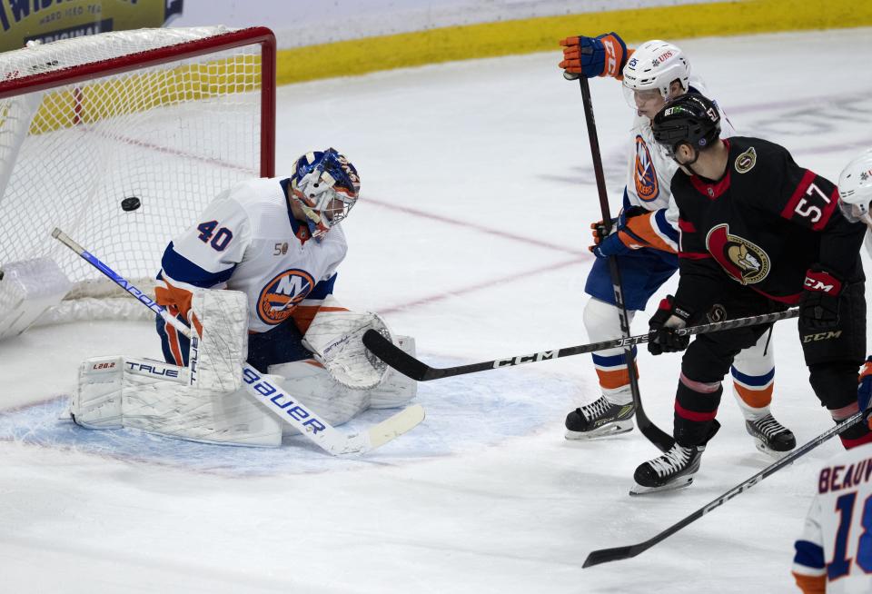 Ottawa Senators center Shane Pinto scores on New York Islanders goaltender Semyon Varlamov as Islanders defenseman Sebastian Aho defends during the first period of NHL hockey game, Wednesday, Jan. 25, 2023 in Ottawa, Ontario. (Adrian Wyld/The Canadian Press via AP)