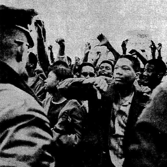 A Black student gives presidential hopeful George Wallace a thumbs-down during a rally outside the Old Courthouse in Evansville, Indiana, on Oct. 10, 1968.