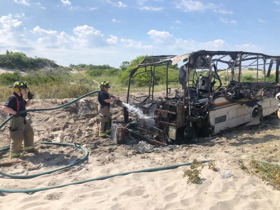 West Barnstable fire crews hose down an RV that was totally involved in flames on the access trail out to Sandy Neck Beach on Wednesday morning.