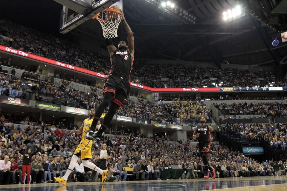 Miami Heat forward LeBron James (6) scores a break away dunk in front of Indiana Pacers forward Paul George (24) during the first half of an NBA basketball game in Indianapolis, Wednesday, March 26, 2014. (AP Photo/AJ Mast)