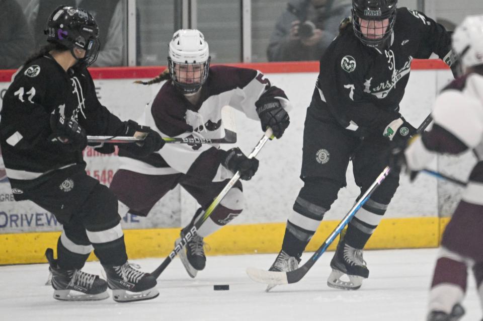 BOURNE  03/10/24 Hadley Vieira of Falmouth moves between Gabby Reardon (e1e1) and Sarah McIntyre of Marshfield. girls hockey
Ron Schloerb/Cape Cod Times