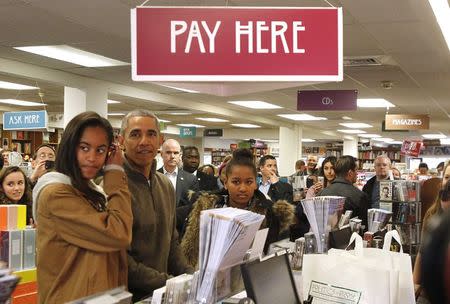 U.S. President Barack Obama and his daughters Sasha and Malia (L) shop at Politics and Prose bookstore in Washington November 29, 2014. REUTERS/Yuri Gripas