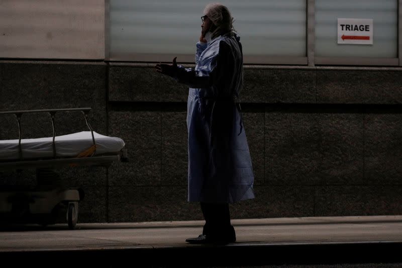 A doctor uses his phone outside the emergency center at Maimonides Medical Center during the outbreak of the coronavirus disease (COVID19) in the Brooklyn, New York