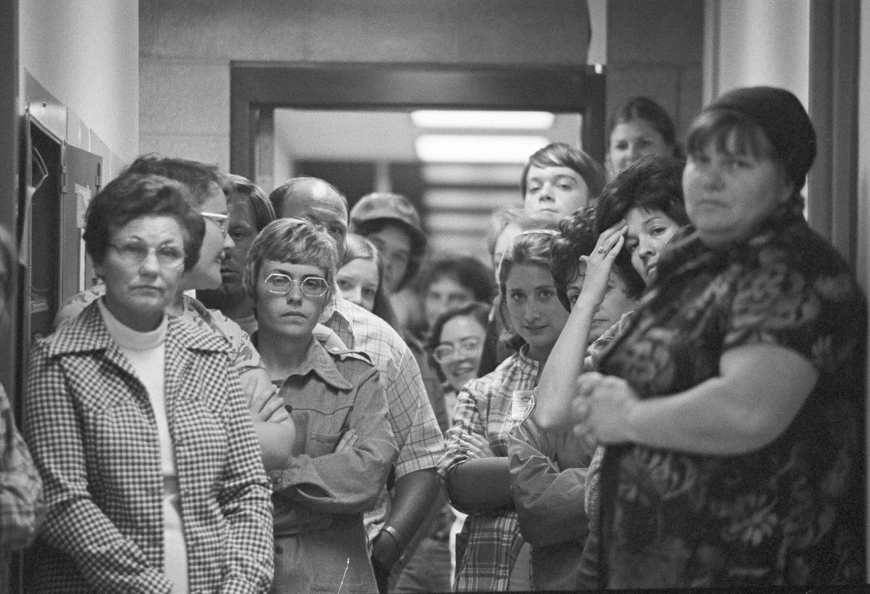 FILE - In this July 17, 1976, photo parents and families of the Dairyland Union School District children and their bus driver who were kidnapped, wait anxiously inside the Chowchilla police station as the students unload from the chartered bus that returned them from Livermore, Calif., where they were found. California parole commissioners have recommended parole for the last of three men convicted of hijacking a school bus full of children for $5 million ransom in 1976. The two commissioners acted Friday, March 25, 2022, in the case of 70-year-old Frederick Woods. (AP Photo, File)