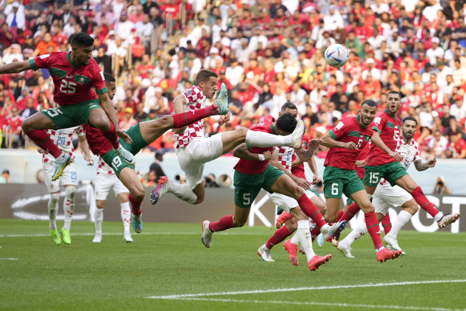 Croatia's Mario Pasalic, center, reaches for the ball during the World Cup group F soccer match between Morocco and Croatia, at the Al Bayt Stadium in Al Khor , Qatar, Wednesday, Nov. 23, 2022. (AP Photo/Manu Fernandez)