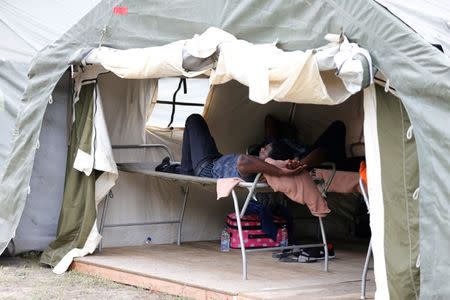 A refugee rests in tents set up by the Canadian Armed Forces near the border in Lacolle, Quebec. Around 250 asylum seekers are arriving each day in Montreal, the largest city in Canada's mainly French-speaking Quebec province. Quebec has opened its Olympic Stadium, a former hospital and a school among other places to house people. REUTERS/Christinne Muschi