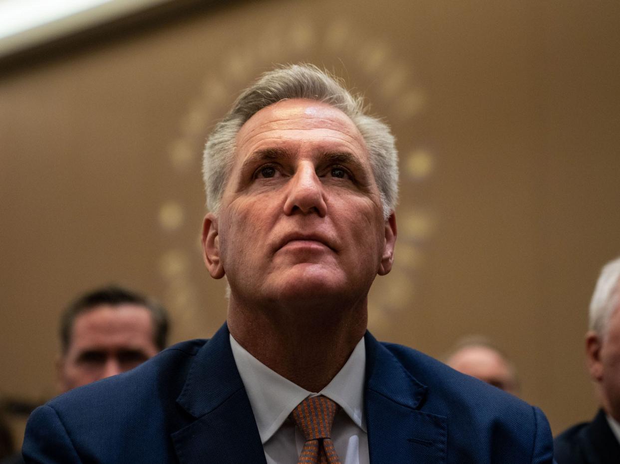 House Minority Leader Kevin McCarthy listens as Former President Donald Trump speaks at the American First Policy Institute's America First Agenda summit at the Marriott Marquis on Tuesday, July 26, 2022 in Washington, DC.