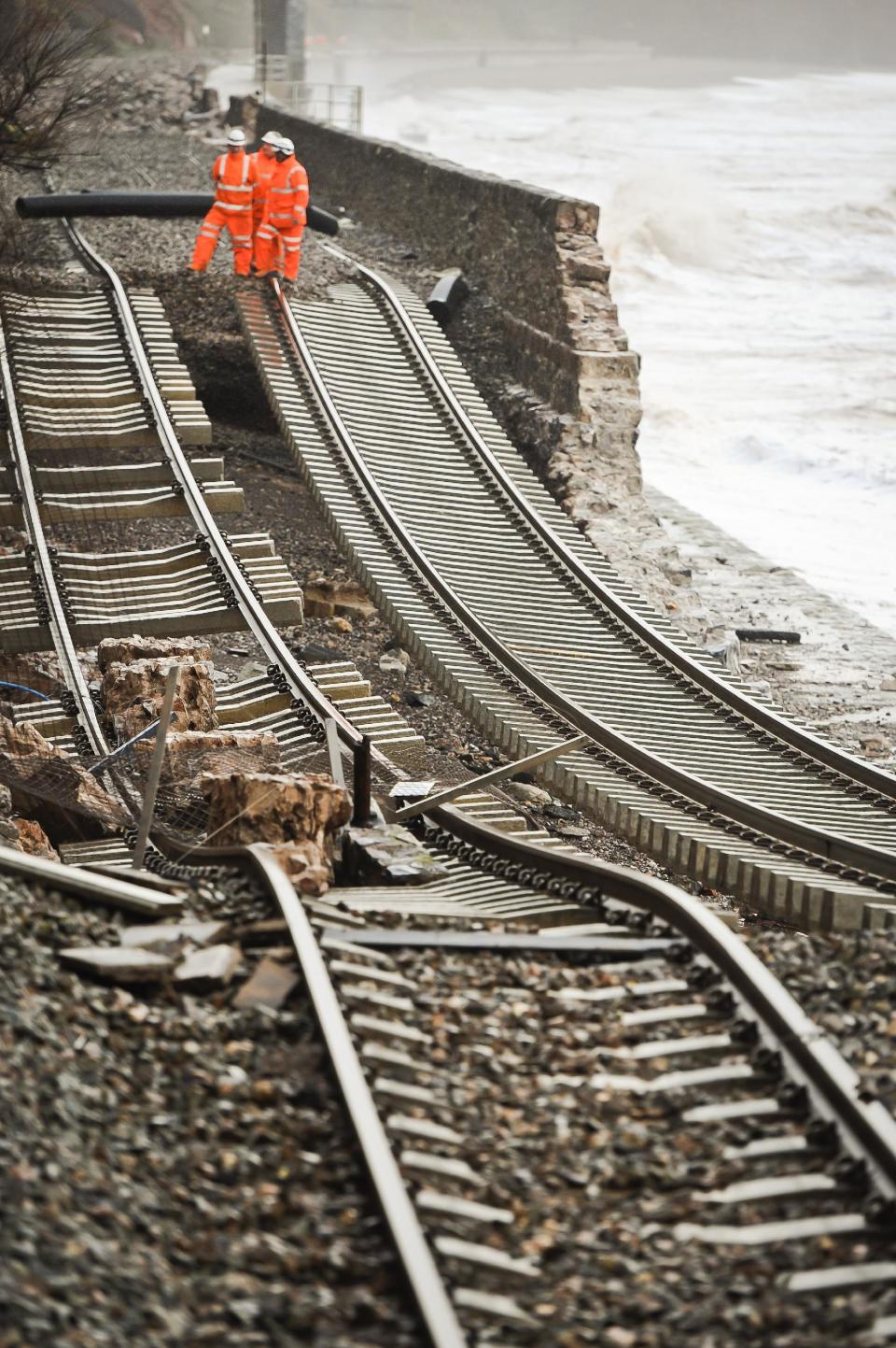 A huge length of railway track is exposed and left hanging after the sea wall collapsed in Dawlish, England, Wednesday, Feb. 5, 2014. Heavy rain, high tides and strong winds pounded England’s southern coast Wednesday, washing away a stretch of rail line, damaging an iconic seaside pier and leaving thousands of homes without power. (AP Photo/PA, Ben Birchall) UNITED KINGDOM OUT, NO SALES, NO ARCHIVE