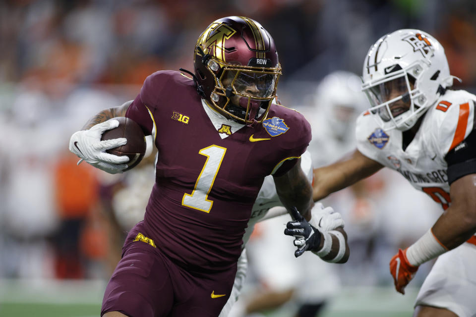 Minnesota running back Darius Taylor (1), left, rushes against Bowling Green linebacker Cashius Howell (0), right, and Bowling Green safety Darius Lorfils (9), rear, during the first half of the Quick Lane Bowl NCAA college football game, Tuesday, Dec. 26, 2023, in Detroit. (AP Photo/Al Goldis)