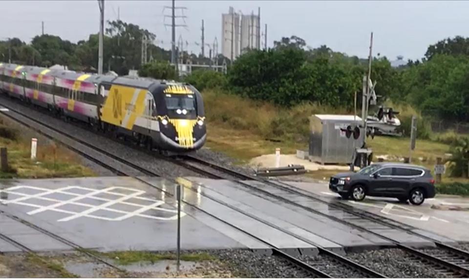 In this screen image from video, a Brightline train #116 that was stopped at Avenue A (southbound) with the crossing arms up, then started across the intersection before the crossing arms came down on Wednesday, Sept. 19, 2023, in Fort Pierce. I