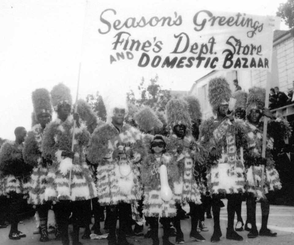 A black and white image of Junkanoo paraders in 1956, featuring Arlene Nash as a child at the front.