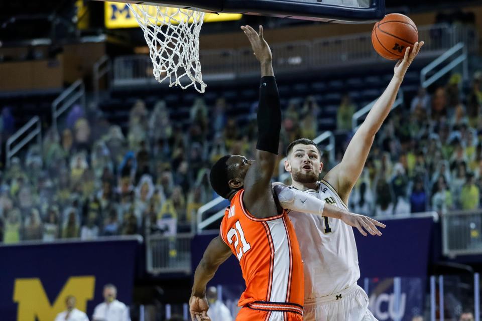 Michigan center Hunter Dickinson (1) makes a layup against Illinois center Kofi Cockburn (21) during the first half Tuesday, March 2, 2021, at the Crisler Center in Ann Arbor.