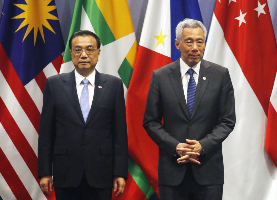 Chinese Premier Li Keqiang, left, and Singapore Prime Minister Lee Hsien Loong, prepare for a group photo with ASEAN leaders prior to the start of the ASEAN Plus China Summit in the ongoing 33rd ASEAN Summit and Related Summits Wednesday, Nov. 14, 2018 in Singapore. (AP Photo/Bullit Marquez)
