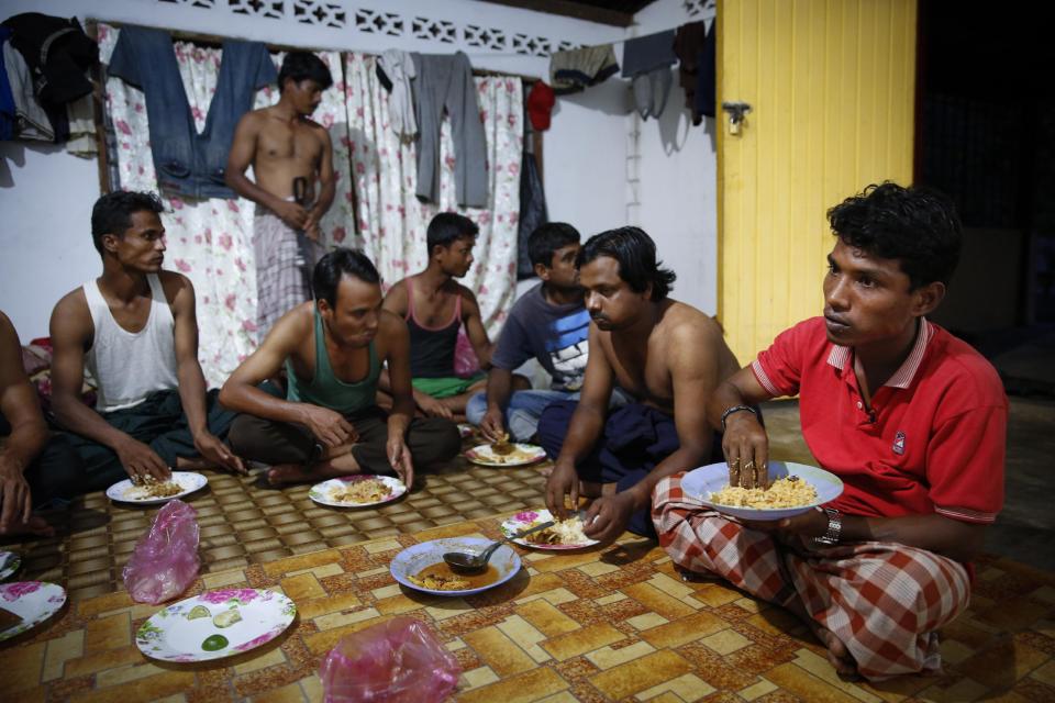 In this Nov. 23, 2013 photo, Rohingya refugee Mohamad Husein, right, from Myanmar, eats dinner at his hostel with his compatriots on the outskirts of Alor Setar, Kedah, North Malaysia. For many fleeing Rohingya, Malaysia, is the preferred destination. Around 33,000 are registered there and an equal number are undocumented, according to the Rohingya Society of Malaysia. Those numbers have swelled with the violence in Myanmar. (AP Photo/Vincent Thian)