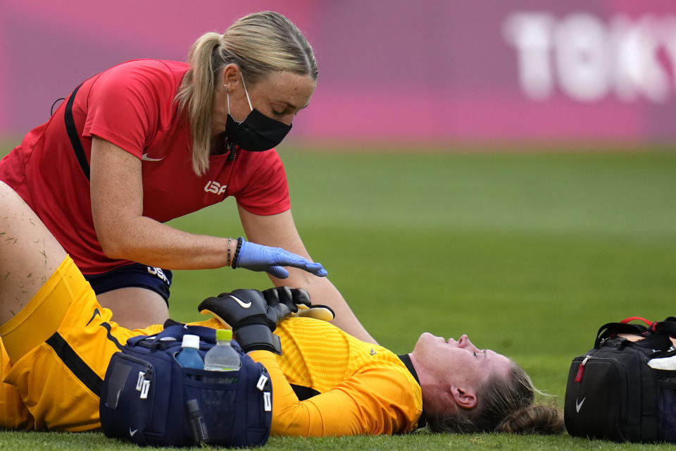 United States' goalkeeper Alyssa Naeher, below, lies on the field during a women's semifinal soccer match against Canada at the 2020 Summer Olympics, Monday, Aug. 2, 2021, in Kashima, Japan. (AP Photo/Fernando Vergara)
