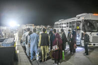 In this image provided by the U.S. Air Force, a group of Afghan evacuees depart a bus at Ramstein Air Base, Germany, Friday, Aug. 20, 2021. Ramstein Air Base is providing safe, temporary lodging for qualified evacuees from Afghanistan as part of Operation Allies Refuge during the next several weeks. (Senior Airman Jan K. Valle/U.S. Air Force via AP)