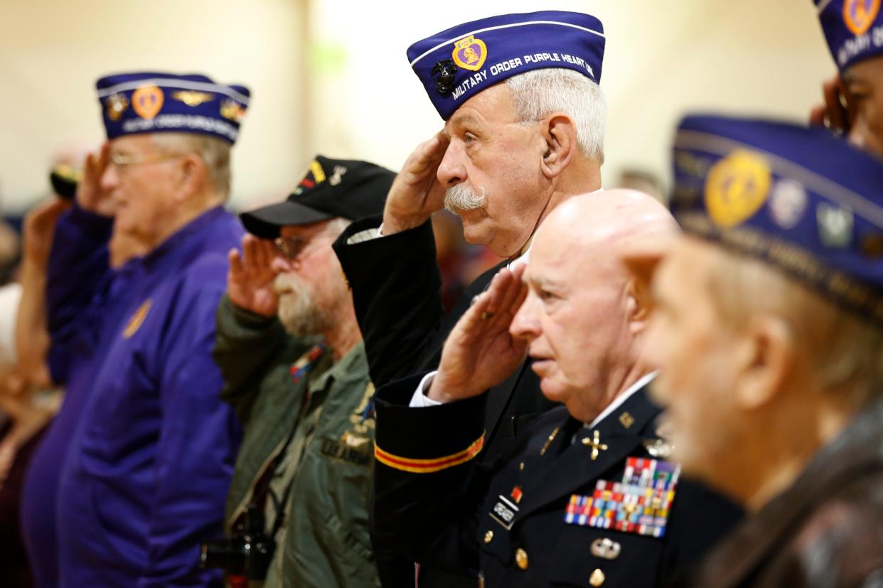 Veterans salute during the presentation of the colors during the Oconee Veterans Memorial Foundation's Veterans Day Program at Oconee Veterans Park in Watkinsville, Ga., on Thursday, Nov. 11, 2021.