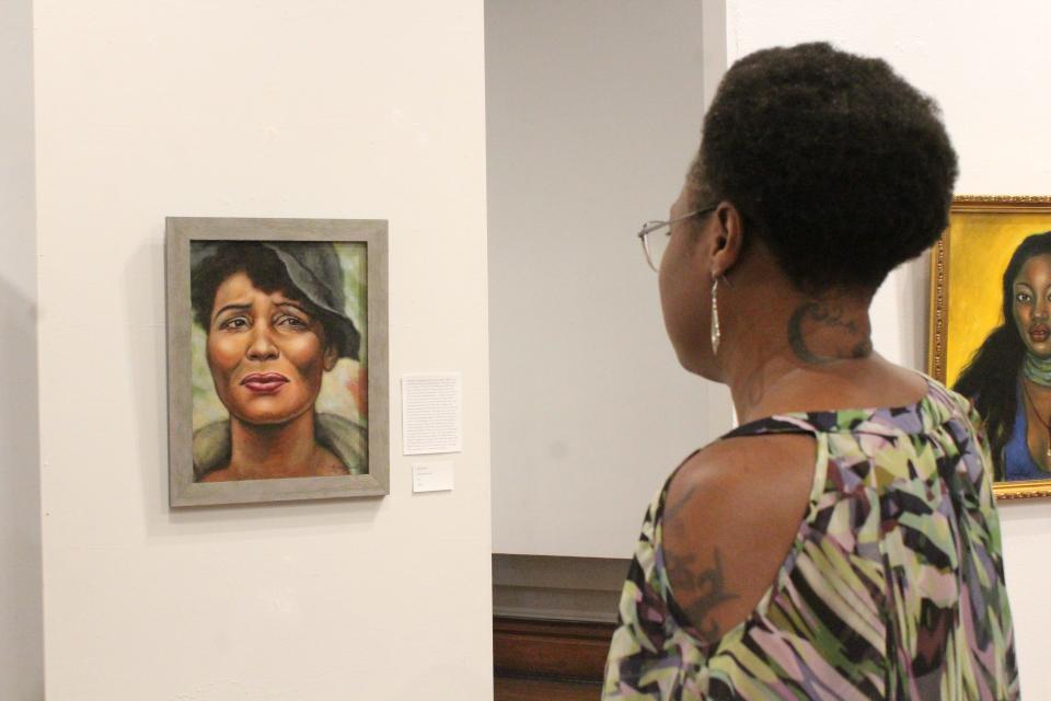 Organizer of the Afrocentric Vision exhibit Allison Allison observes her favorite piece of art titled "What We Lose," by Kara Priest