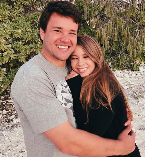 Bindi Irwin and Chandler Powell hug on an Australian beach