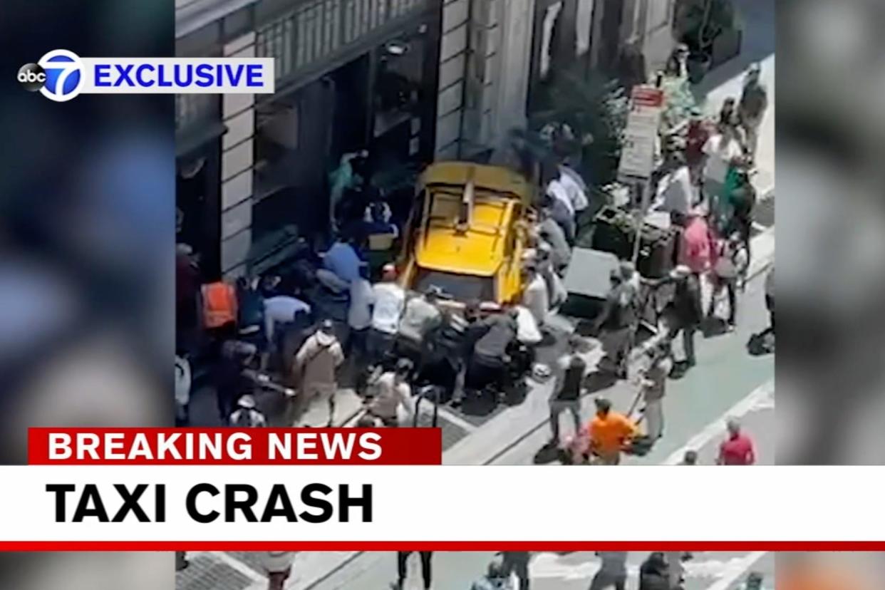 Bystanders move in to assist pedestrians who were struck by a cab that jumped a curb Monday in this screenshot from WABC-TV. A taxi cab turning onto a narrow section of Broadway hit a bicyclist, then swerved onto a Manhattan sidewalk and into a group of pedestrians Monday afternoon, critically injuring three people, police said.