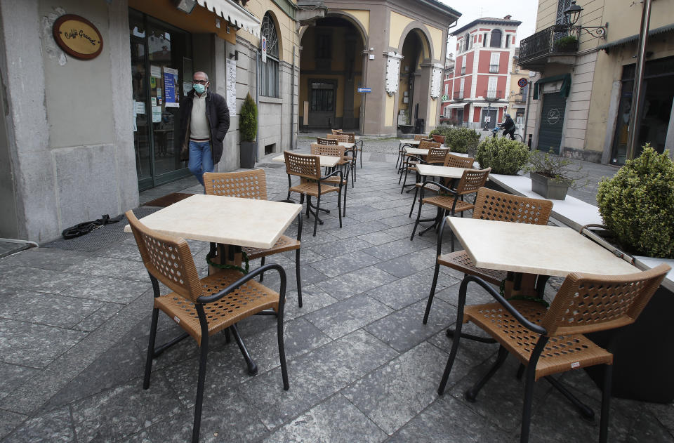 In this photo taken on Thursday, March 12, 2020, a man wearing a mask walks in Codogno, Italy. The northern Italian town that recorded Italy’s first coronavirus infection has offered a virtuous example to fellow Italians, now facing an unprecedented nationwide lockdown, that by staying home, trends can reverse. Infections of the new virus have not stopped in Codogno, which still has registered the most of any of the 10 Lombardy towns Italy’s original red zone, but they have slowed. For most people, the new coronavirus causes only mild or moderate symptoms. For some it can cause more severe illness. (AP Photo/Antonio Calanni)