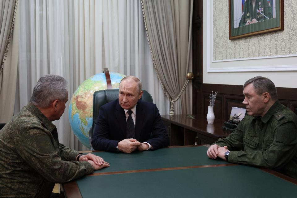 Putin speaks to defence minister Sergei Shoigu (L) and military chief Valery Gerismov (R) in southern Russia (via REUTERS)