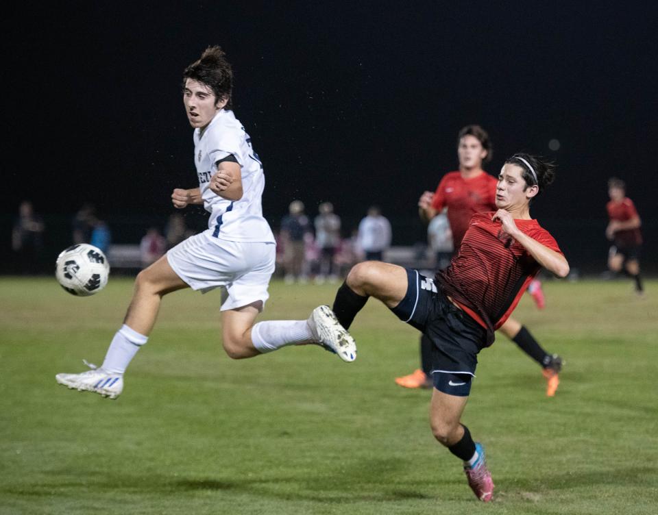 Reynaldo Portugal (14) passes the ball past Gavin Gailey (12) during the Gulf Breeze vs West Florida boys soccer game at Ashton Brosnaham Park in Pensacola on Wednesday, Dec. 7, 2022.