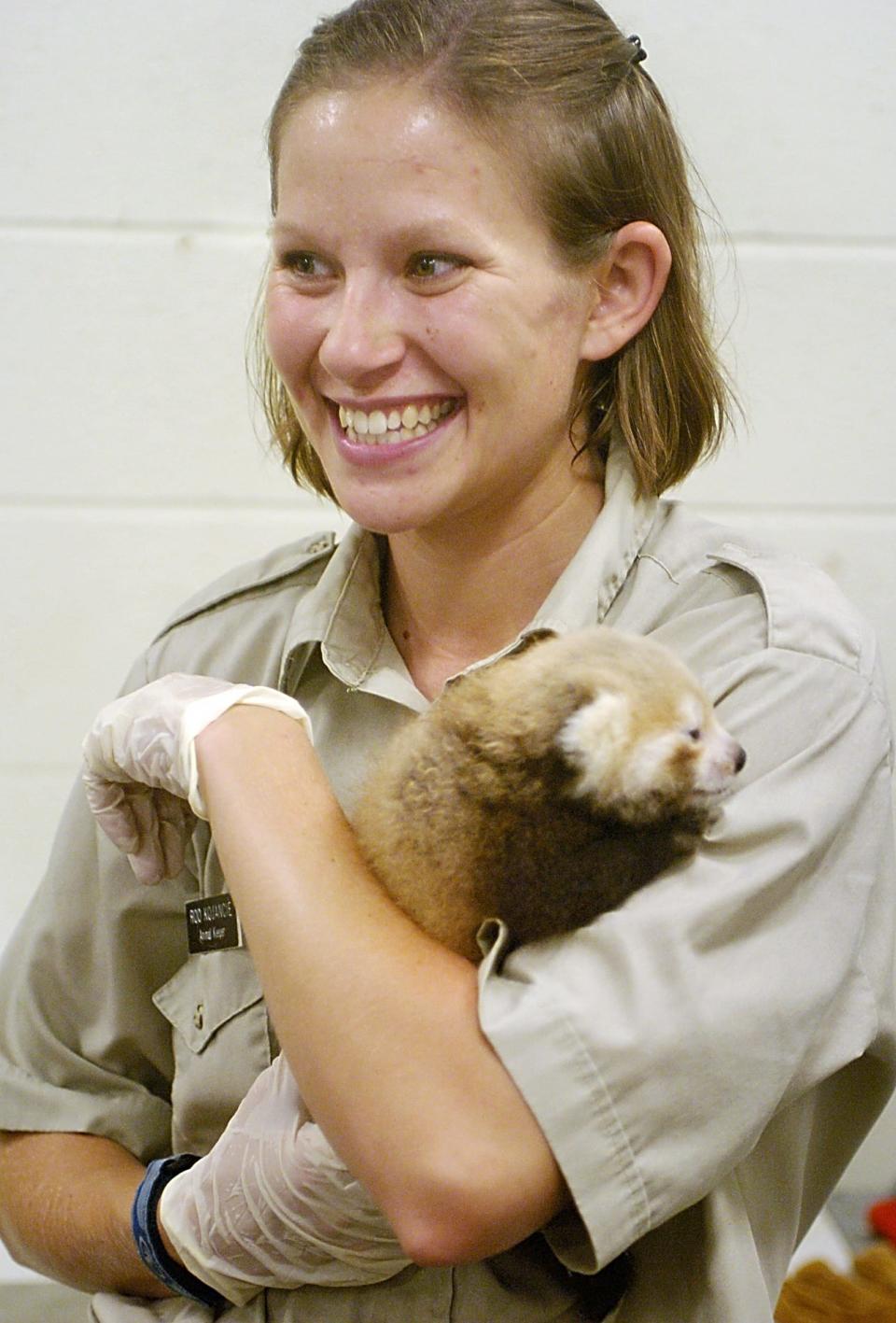 Melissa "Roo" Kojancie, then a zookeeper at the Erie Zoo, is shown in this 2005 file photo holding a baby red panda.