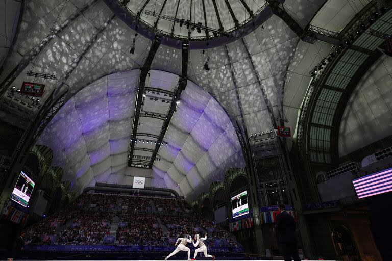 La italiana Martina Favaretto (i) y la estadounidense Lauren Scruggs (derecha) compiten en el combate por la medalla de oro por equipos de florete femenino 