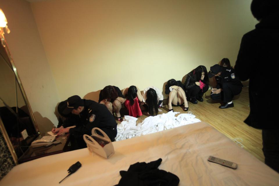 Police write down the details of suspects who were detained during a police raid, as part of plans to crackdown on prostitution, at a hotel in Dongguan, Guangdong province, February 9, 2014. Chinese authorities have carried out a rare crackdown on the sex trade in the "sin city" of Dongguan following a candid report by the state broadcaster on the underground industry. Picture taken February 9, 2014. REUTERS/Stringer (CHINA - Tags: CRIME LAW) CHINA OUT. NO COMMERCIAL OR EDITORIAL SALES IN CHINA