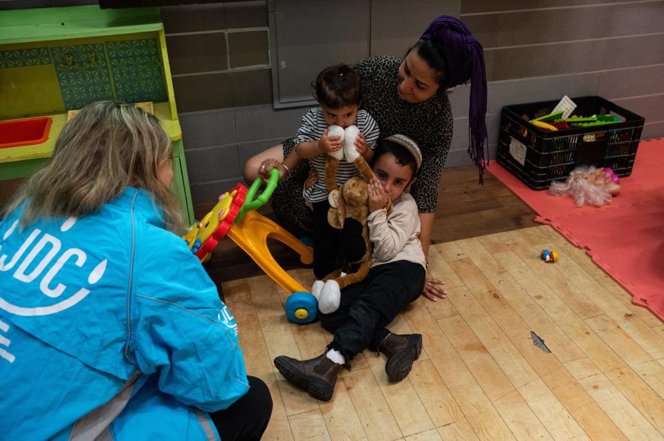 A JDC worker in Jerusalem teaches an evacuated family from Sderot how to use the Hibuki trauma therapy doll, which has been used by the organization to heal thousands of traumatized children from Israeli border towns under rocket fire since 2006.