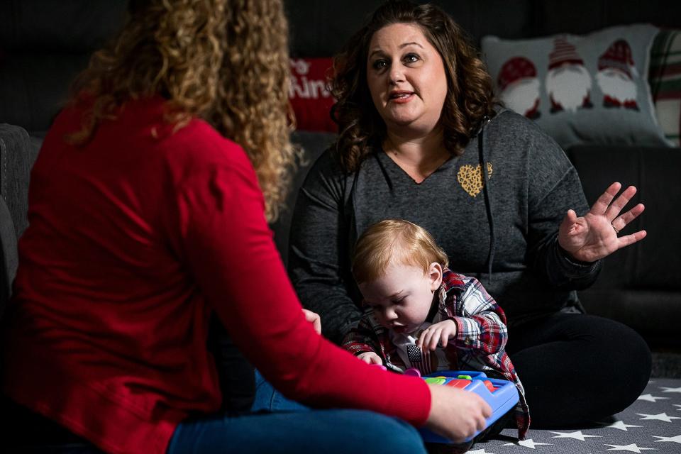 Nicole Keene, right, talks with therapist Rebecca Vellenoweth while holding her 1-year-old son, Wesson Keene, during a recent therapy session at their home in Lexington, Ky. In June, Wesson’s doctor diagnosed him with cerebral palsy.