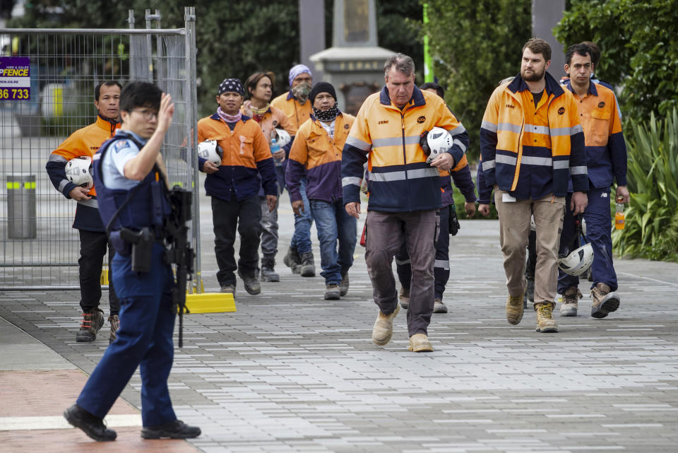 Construction workers are escorted by police in the central business district following a shooting in Auckland, New Zealand, Thursday, July 20, 2023. New Zealand police are responding to reports that a gunman has fired shots in a building in downtown Auckland. (Jason Oxenham/NZ Herald via AP)