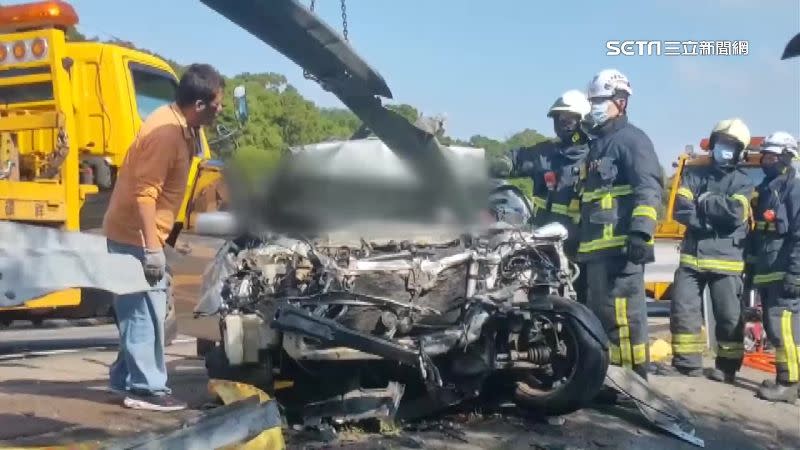 轎車撞到幾乎崁進護欄，消防員破壞車體還出動吊車。