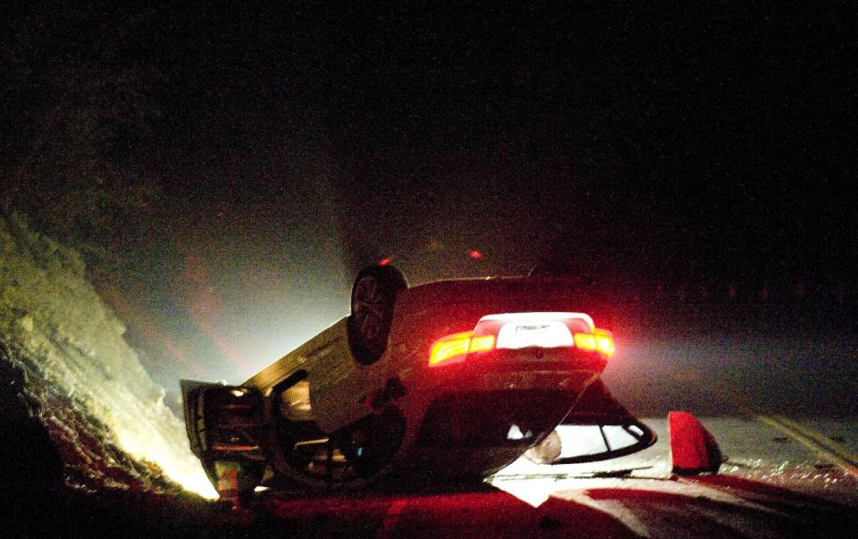 A car sits rolled over in the wake of Friday nights March 28, 2014 earthquake on Carbon Canyon Road in Brea, Calif., near Olinda Village. (AP Photo/The Orange County Register, Rod Veal)