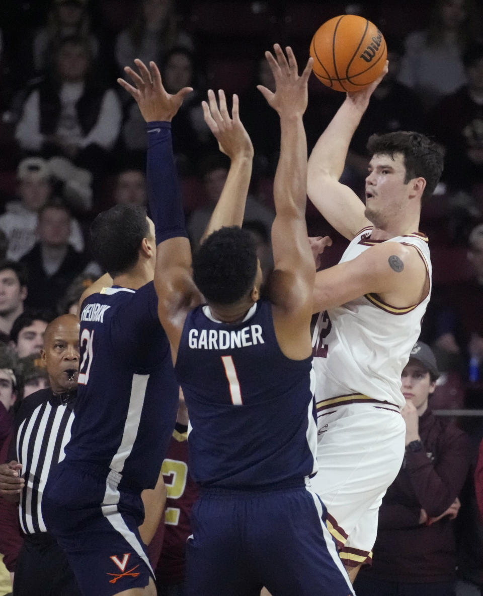 Boston College forward Quinten Post, right, passes the ball while pressured by Virginia's Jayden Gardner (1) and Kadin Shedrick, left, during the first half of an NCAA college basketball game, Wednesday, Feb. 22, 2023, in Boston. (AP Photo/Charles Krupa)