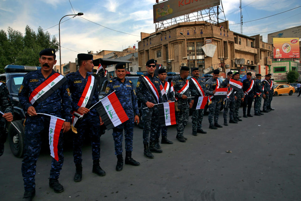 Federal police surround the protest site during clashes between security forces and anti-government protesters in central Baghdad, Iraq, Sunday, Oct. 25, 2020. Thousands of Iraqi protesters have taken to the streets to mark one year since mass anti-government demonstrations swept Baghdad and Iraq's south. Protesters marched Sunday in the capital and several southern cities to renew demands to bring an end to corruption perpetuated by Iraq's politicians. (AP Photo/Khalid Mohammed)