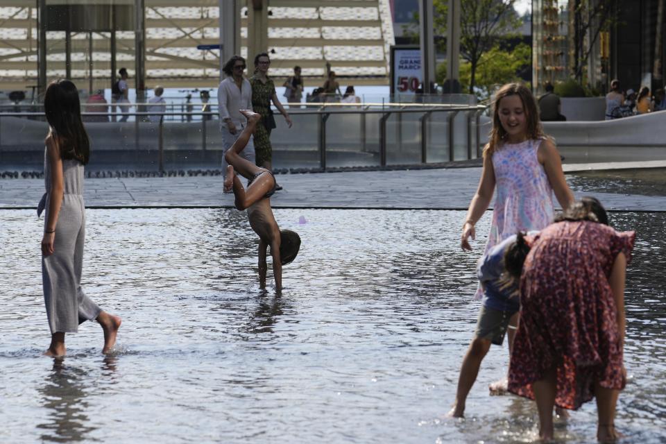 Children cool down in a public fountain, in Milan, Italy, Saturday, July 15, 2023. Temperatures reached up to 42 degrees Celsius in some parts of the country, amid a heat wave that continues to grip southern Europe. (AP Photo/Luca Bruno)