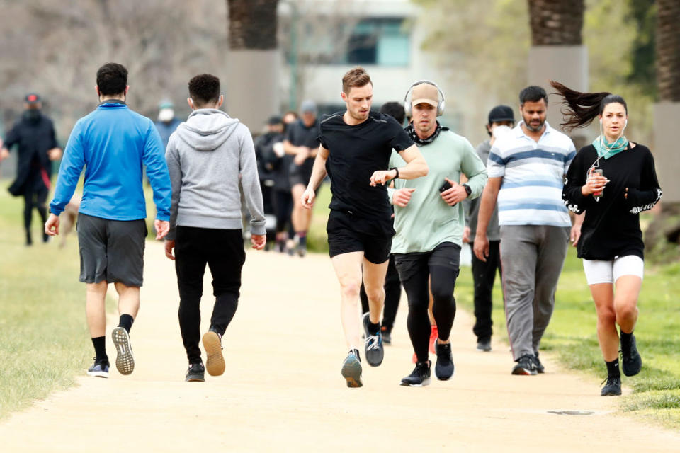 People enjoy their one hour of exercise allowed under stage 4 restrictions at Albert Park in Melbourne. 