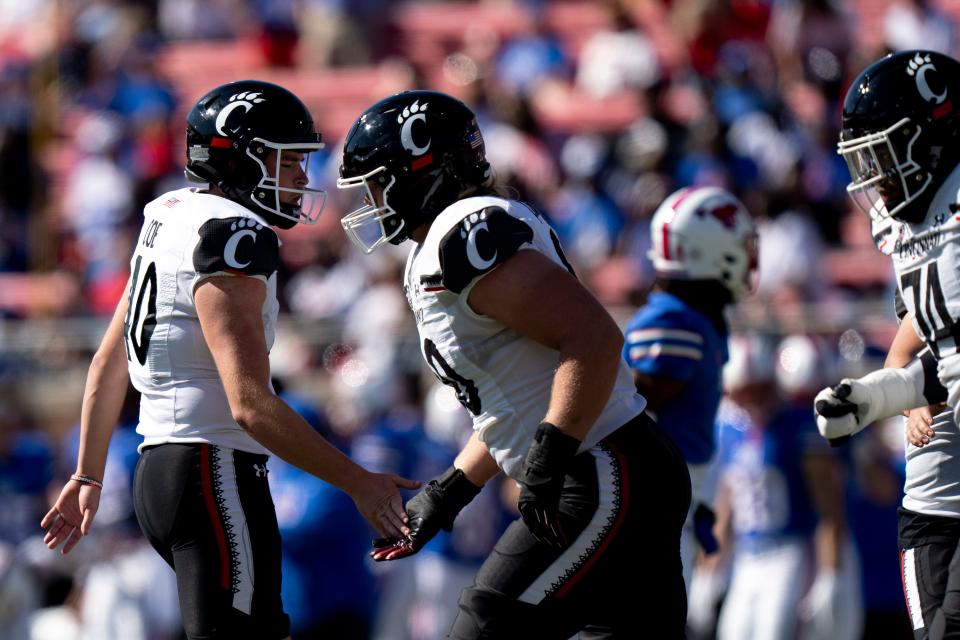 Cincinnati Bearcats place kicker Ryan Coe (40) celebrates with Cincinnati Bearcats offensive lineman Joe Huber (60) after hitting a field goal in the first quarter of the American Athletic Conference game between the Cincinnati Bearcats and the Southern Methodist Mustangs at Gerald J. Ford Stadium in Dallas on Saturday, Oct. 22, 2022.