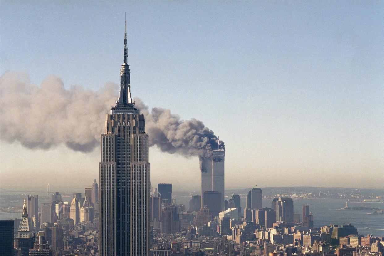 In this Sept. 11, 2001, file photo the Twin Towers of the World Trade Center burn behind the Empire State Building in New York after terrorists crashed two planes into the towers causing both to collapse.