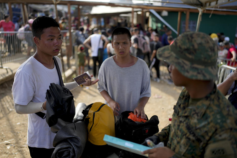 Panamanian border police check Chinese migrants who walked across the Darien Gap from Colombia, upon their arrival in Bajo Chiquito, Panama Saturday, May 6, 2023. (AP Photo/Natacha Pisarenko)