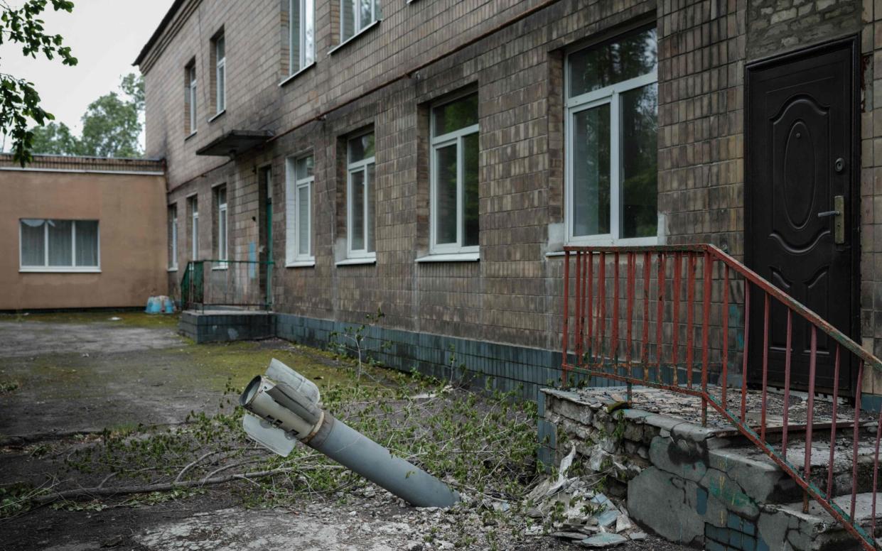 TOPSHOT - An unexploded ordnance is seen at a backdoor of a kindergarten where seven people have been sheltering in the basement for more than two months, in Lysychansk, eastern Ukraine, on May 14, 2022. - Intense fighting raged in eastern Ukraine's Donbas region on May 14, 2022, where Russia has been concentrating its forces without making significant progress, while "very difficult negotiations" were under way over the fate of the last besieged defenders in the city of Mariupol. Russia invaded Ukraine on February 24, 2022. (Photo by Yasuyoshi CHIBA / AFP) (Photo by YASUYOSHI CHIBA/AFP via Getty Images) - YASUYOSHI CHIBA/AFP via Getty Images