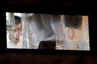 FILE PHOTO: A member of the Zaka Rescue and Recovery team is seen behind a bullet hole in a window as he works inside the home where three Israelis were killed in a stabbing attack in the Jewish settlement of Neve Tsuf, in the occupied West Bank July 22, 2017. REUTERS/Amir Cohen/File Photo