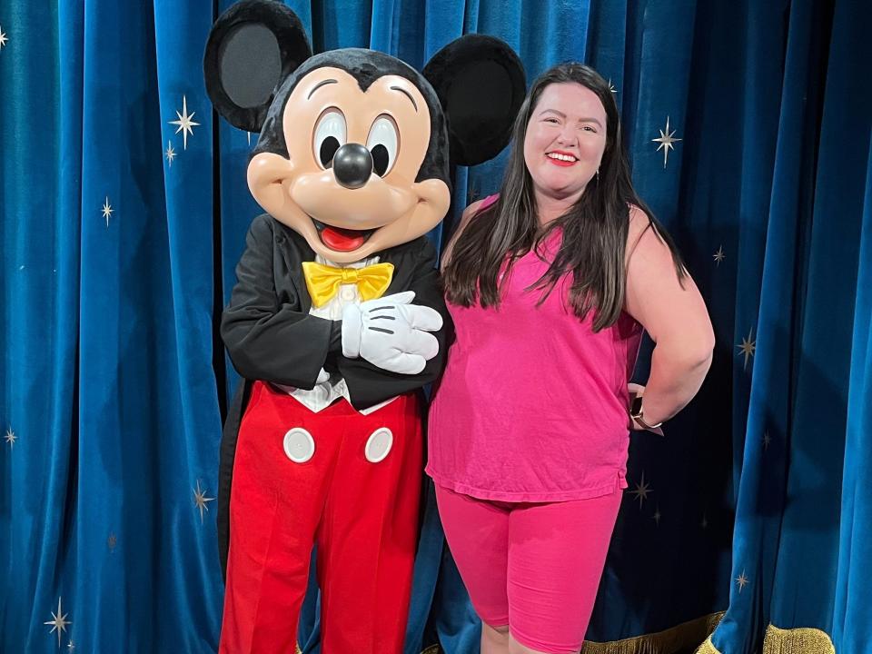 megan posing for a photo with mickey at disney world as an adult