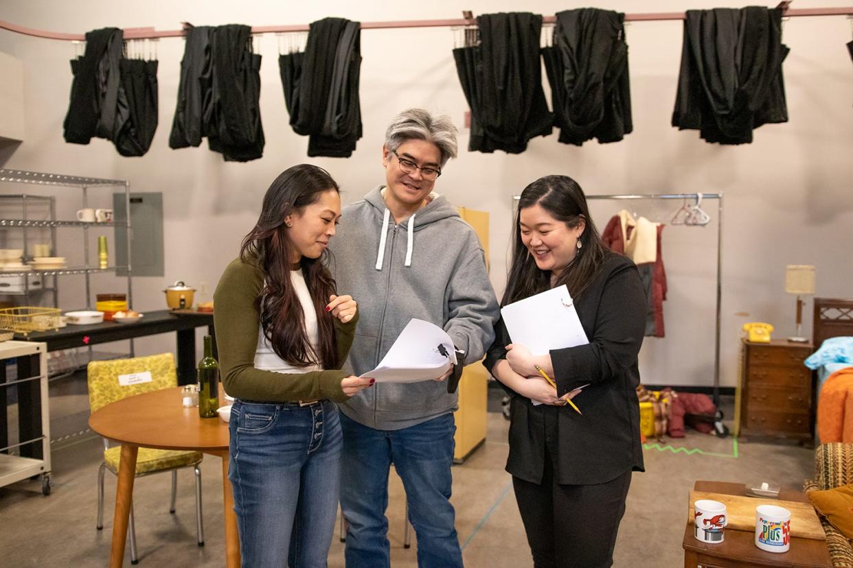 Playwright Lloyd Suh, center, consults with actors Nicole Javier and Narea Kang during the first rehearsal for "The Heart Sellers."