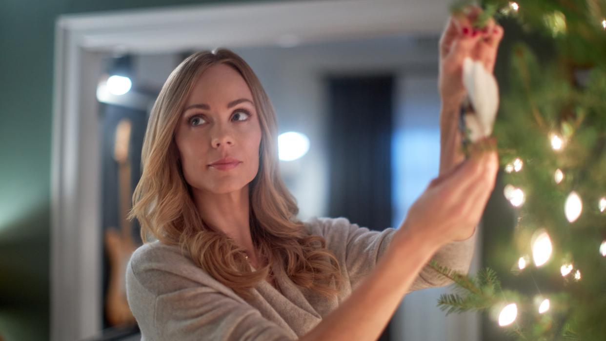  Laura Vandervoort as Mary Ann hangs an ornament on the tree in Miracle in Bethlehem, PA. 