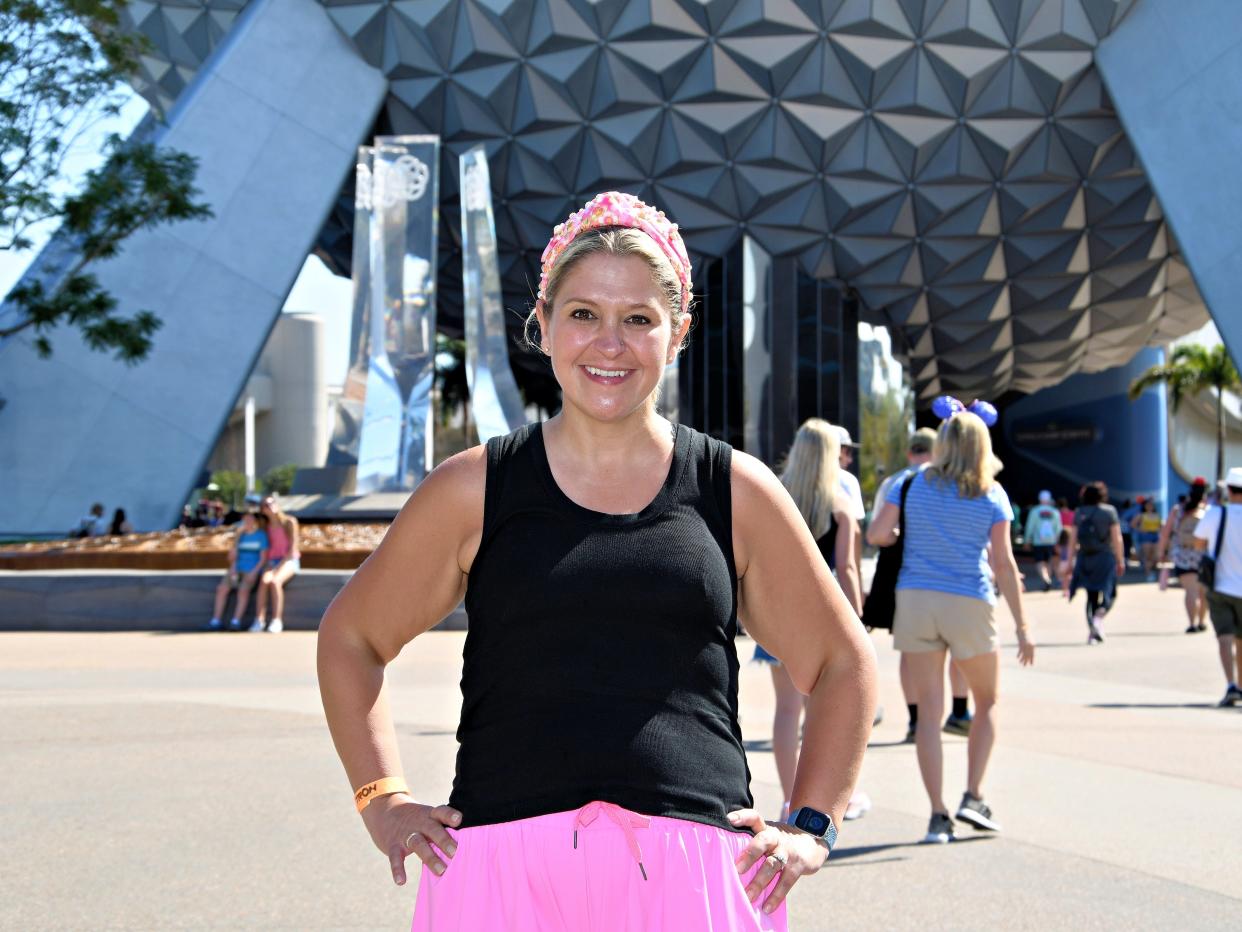 terri posing for a photo in front of the epcot ball in disney world