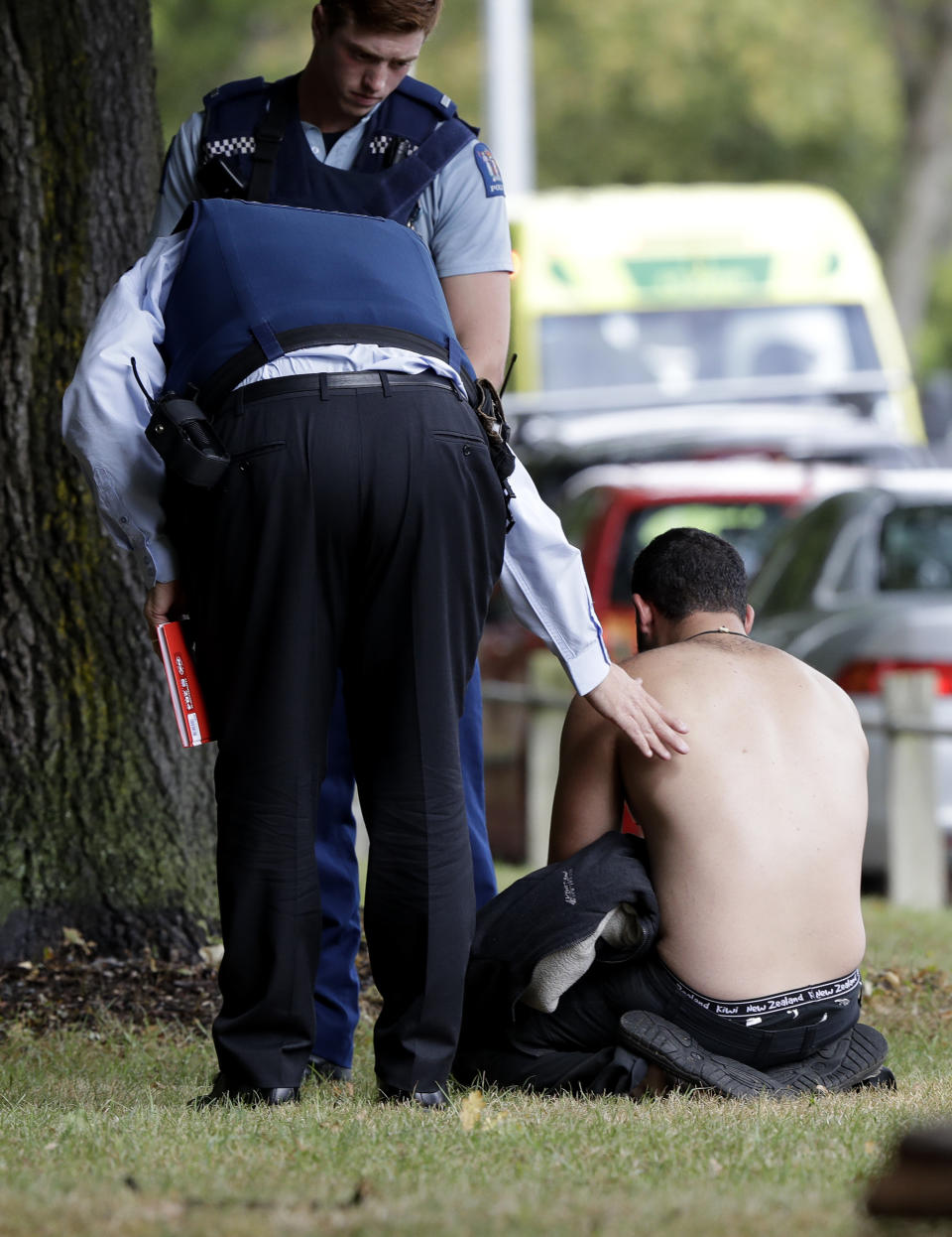 Police console a man outside a mosque in central Christchurch after a mass shooting in New Zealand on March 15, 2019.&nbsp;